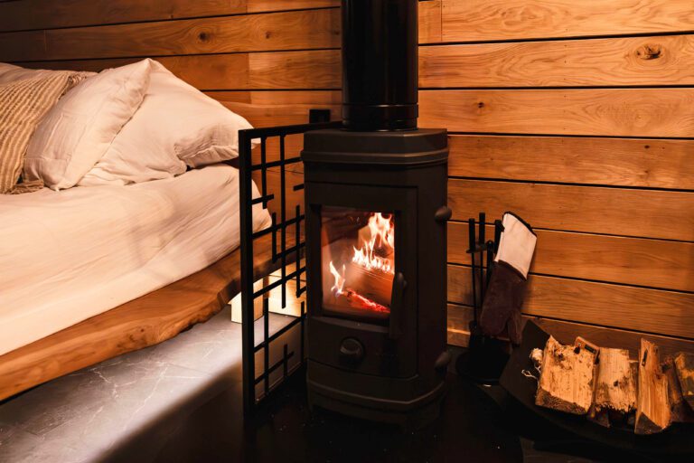 Poêle à bois près du lit aux Cabanes Étoilées près de Bruxelles